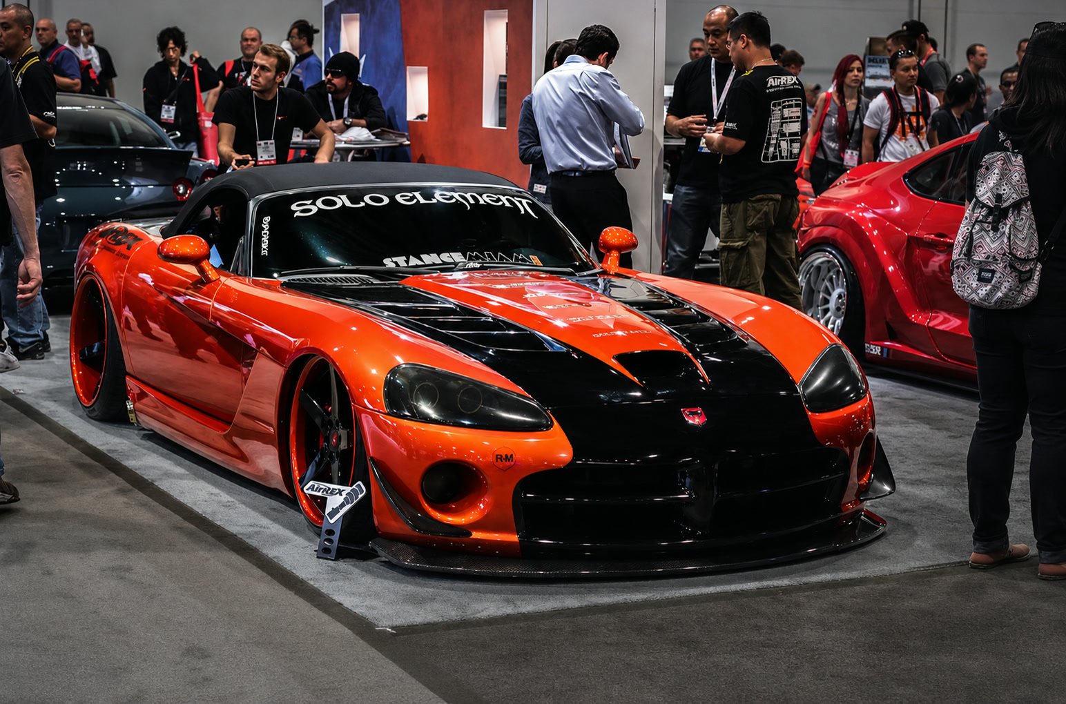 Orange wide-body Dodge Viper with black hood at a show